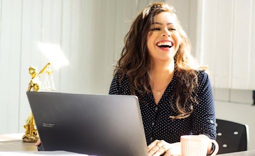 Small Business Cyber Security | Image of woman on laptop smiling | StickmanCyber