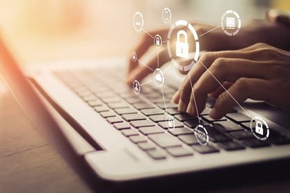 Hands typing on a laptop beneath padlock and network icons.