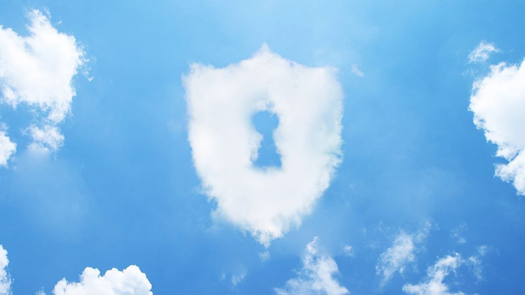 A shield-shaped cloud with a keyhole in a blue sky, illustrating shared cloud security responsibilities.