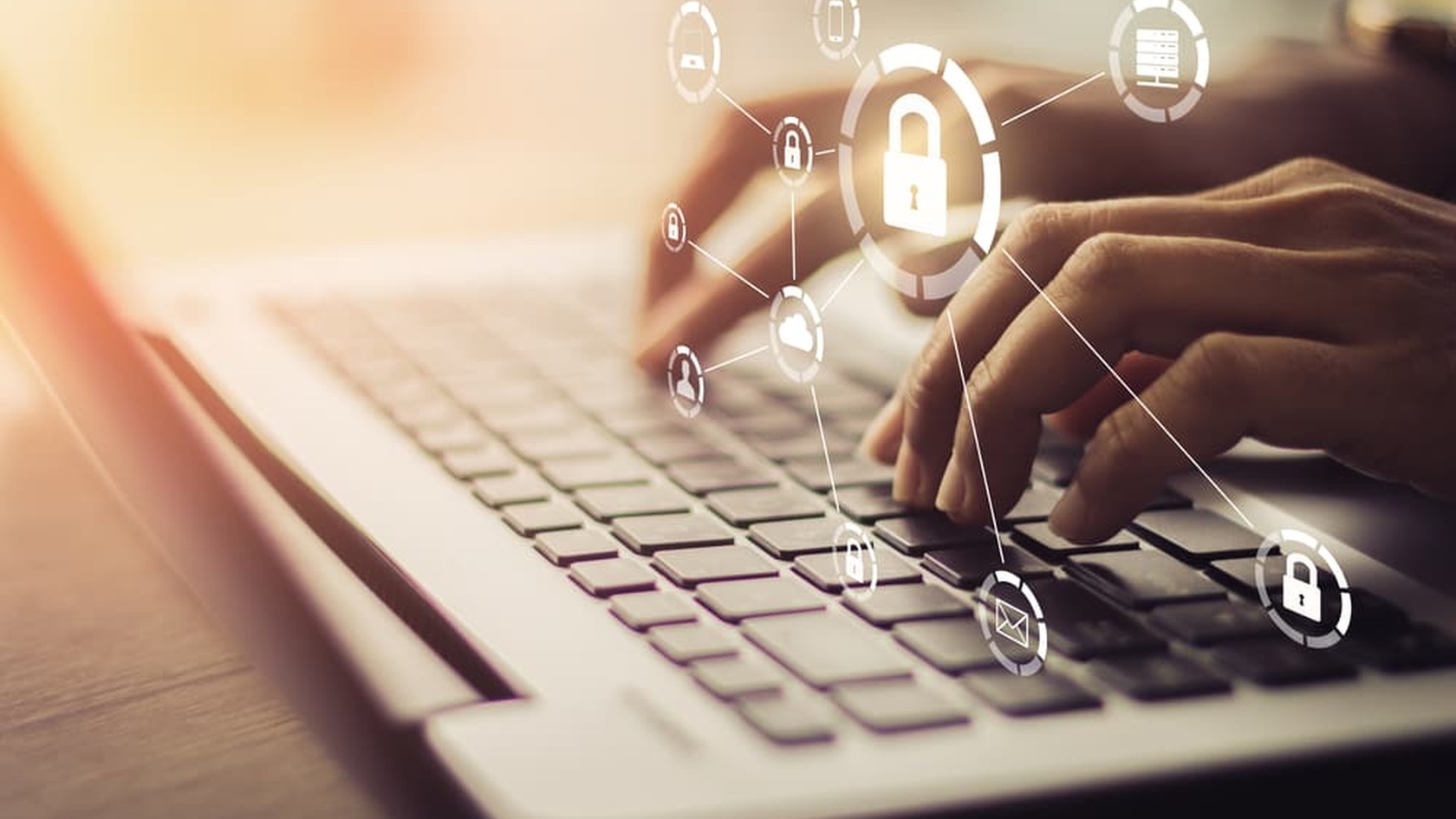 Hands typing on a laptop beneath padlock and network icons, illustrating cybersecurity risk and network protection.