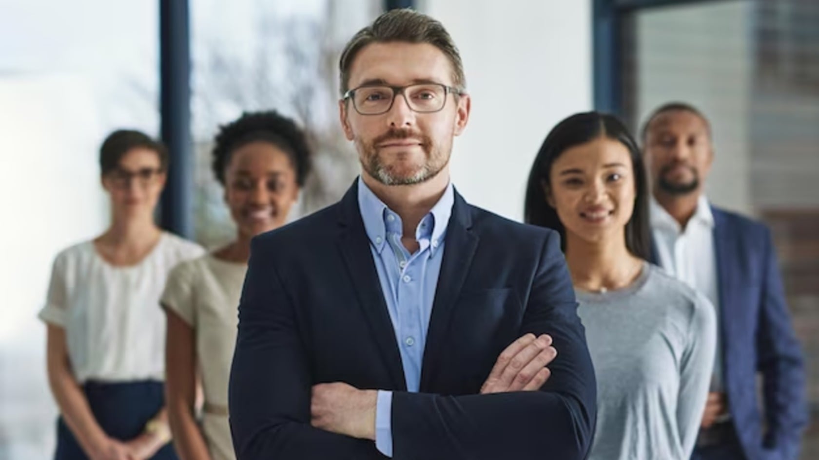 A confident team of business professionals standing together in an office, representing employees as the first line of cyber defense.